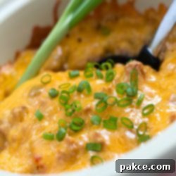Tex-Mex Fiesta Bake 2 South of the Border Casserole in a white bowl with a serving spoon.