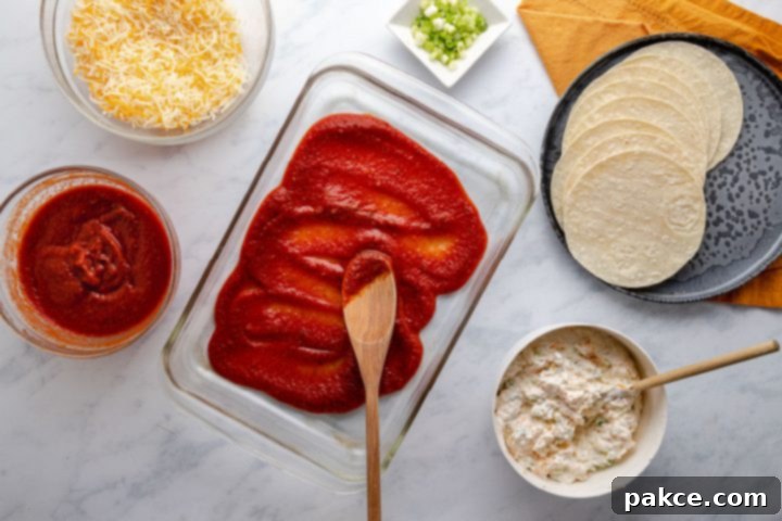 Cheese and Onion Enchiladas 5 A 9x12 inch glass baking pan with a layer of homemade red enchilada sauce spread evenly across the bottom, creating a flavorful base for the enchilada assembly.
