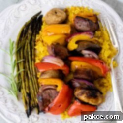 Succulent Beef Kabobs Atop Golden Rice 2 Grilled beef and vegetable kabobs served over yellow rice with grilled asparagus.