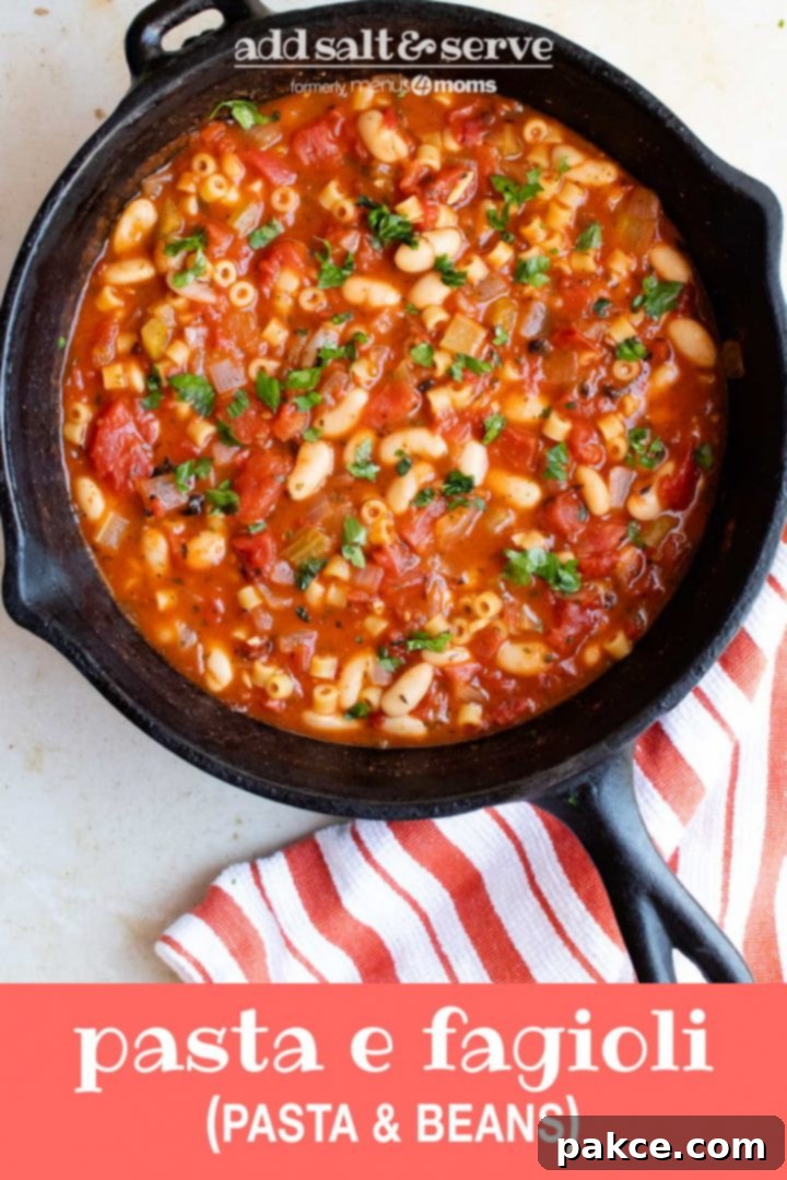 Pasta e Fagioli Cast iron skillet with Pasta e Fagioli, a soup made with pasta, tomatoes, chopped celery, onion, and parsley, cannellini beans, and tomato sauce. There's an orange and white striped towel on the counter to the right of the skillet. Text pasta e fagoioli (pasta & beans) add salt & serve formerly menus4moms
