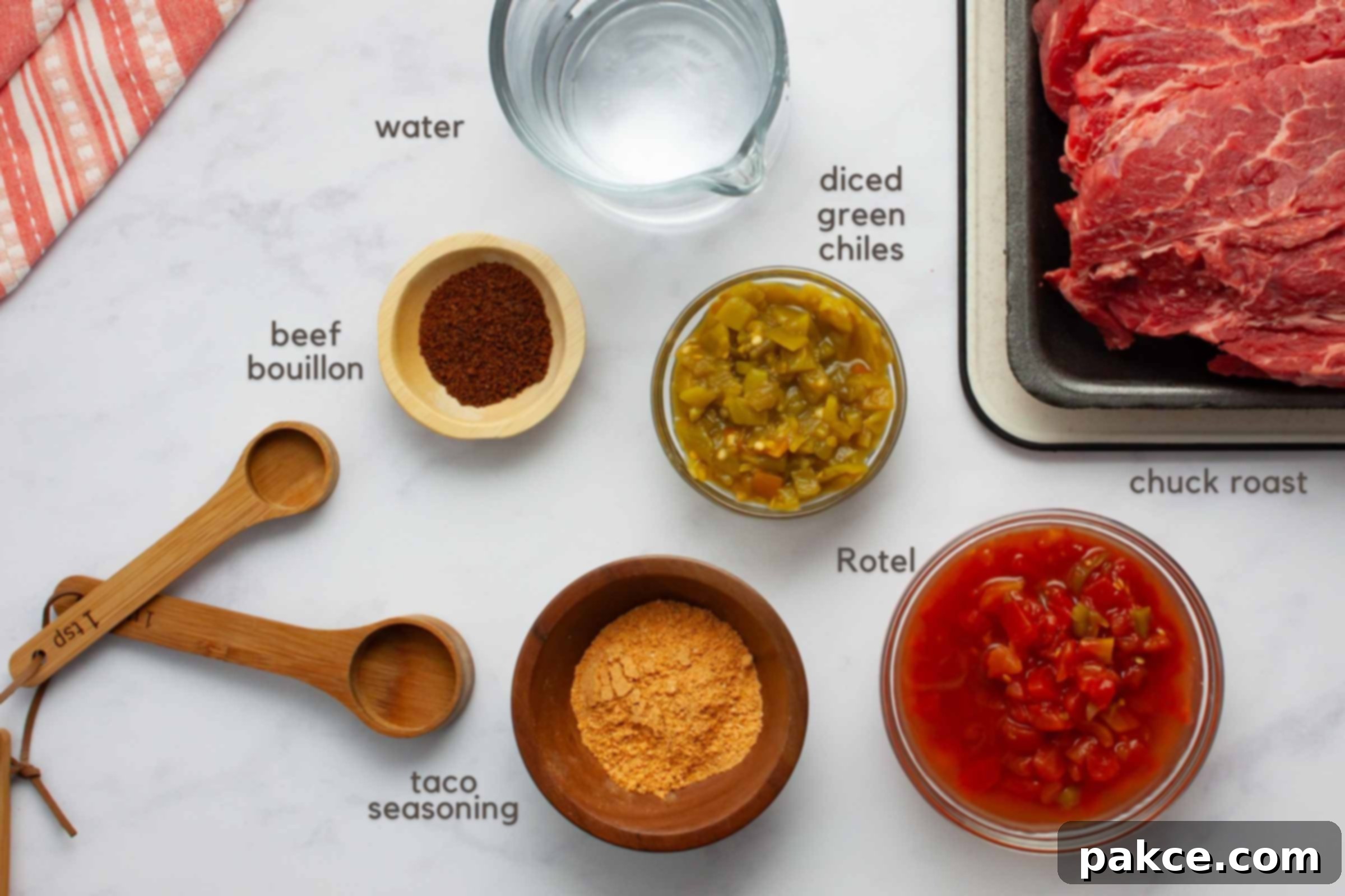 Tender Mexican Slow Cooker Pot Roast 2 Ingredients on a counter: chuck roast, beef bouillon granules, water, diced green chiles, Rotel, and taco seasoning.