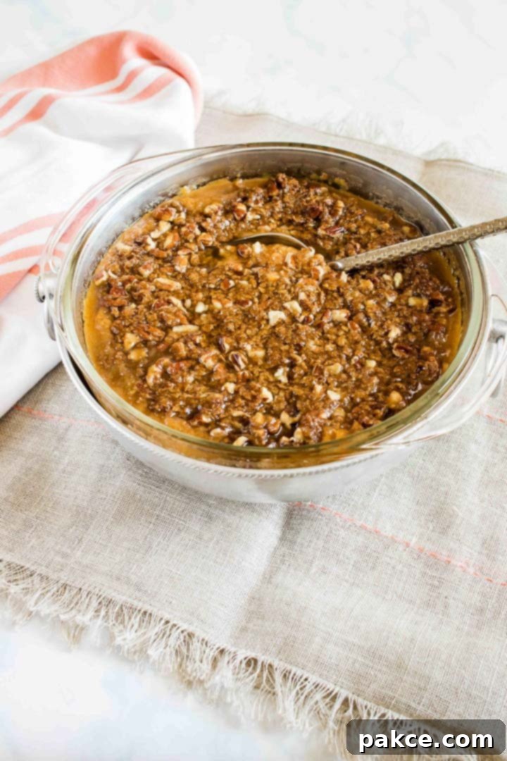 Sweet potato casserole with streusel topping, garnished with fresh herbs and a golden-brown crust