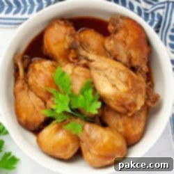 Effortlessly Tender Slow Cooker Chicken Legs 5 Cooked chicken legs in a serving dish garnished with fresh parsley, ready to be served for a family dinner.