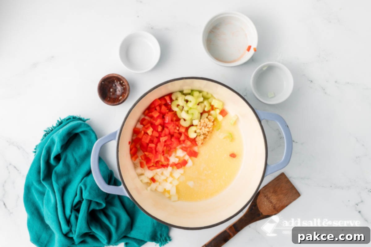 Recreate Olive Garden's Chicken Gnocchi Soup at Home 4 Enamel Dutch oven with melted butter and chopped onion, red bell pepper, celery, and minced garlic sautéing.