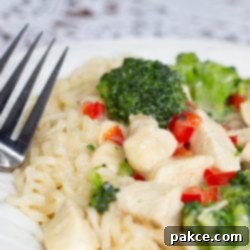Velvety Chicken Broccoli Ramen Bowl 3 A plate with Creamy Chicken and Broccoli Ramen and a fork.