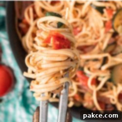 Spiralized Zucchini Linguine 11 Cooked Stovetop Zucchini Linguine wrapped on tongs held over the skillet.