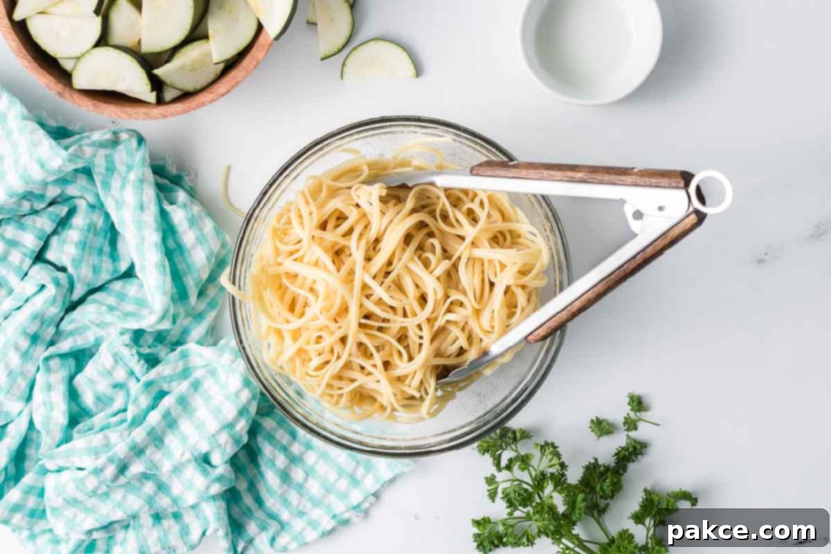 Spiralized Zucchini Linguine 4 Cooked linguine in a bowl with a bowl of sliced zucchini nearby.