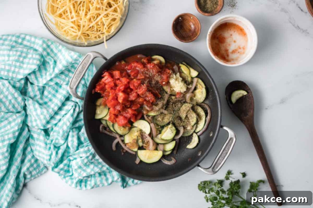 Spiralized Zucchini Linguine 7 Sautéed sliced zucchini and red onion in a skillet with minced garlic, diced canned tomatoes, and Italian seasoning surrounded by dishes of cooked linguine and pepper.