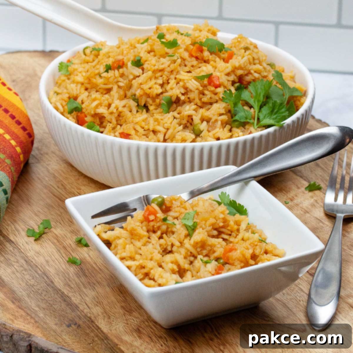 Two bowls of Restaurant Style Mexican Rice, garnished with fresh cilantro and a lime wedge