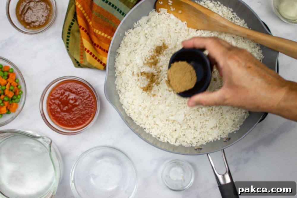 Vibrant Mexican Veggie Rice 5 Diced onions, cumin, and rice in a skillet with all other ingredients for Restaurant Style Mexican Rice ready to be added