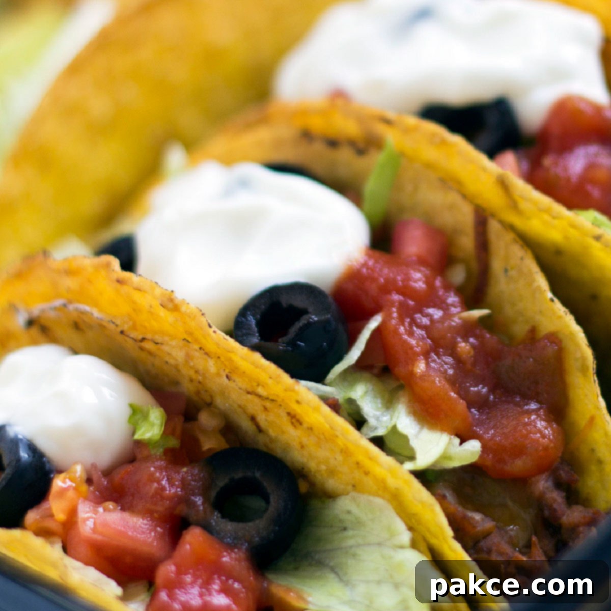 Quick Sheet Pan Beef Tacos 2 Hard-shell tacos with beef, lettuce, olives, salsa, and sour cream