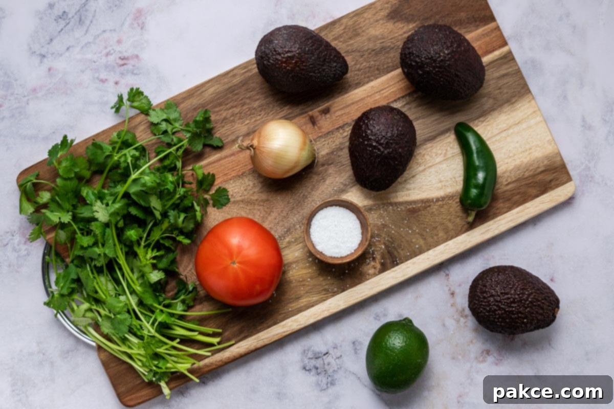 Homemade guacamole ingredients: avocado, onion, tomato, salt, jalapeno, lime, cilantro