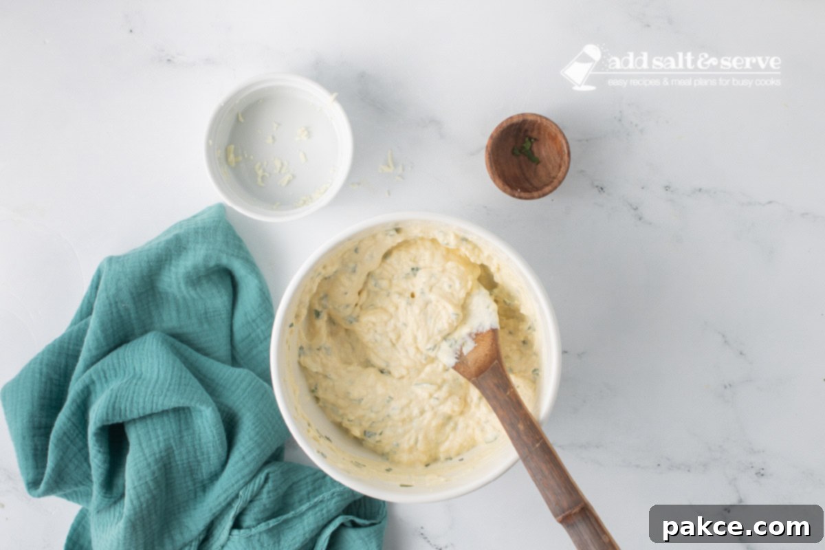 Creamy Alfredo Rotini Bake 5 The bowl from the previous step, now with the ricotta cheese, eggs, mozzarella, parsley, salt, and pepper thoroughly mixed into a creamy, uniform mixture.