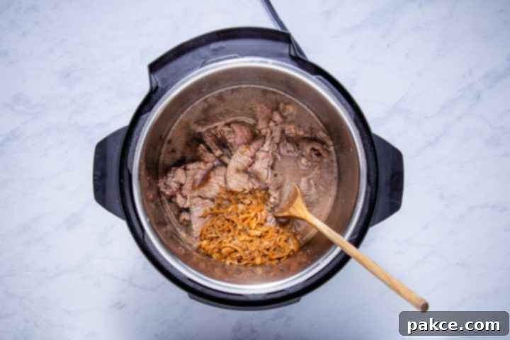 Instant Pot French Onion French Dip 5 sliced sautéed chuck steak, french onion soup, and beef consomme in the instant pot