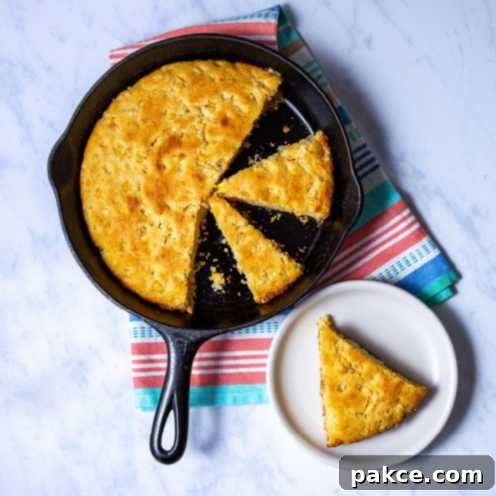 Sliced cornbread in a round cast iron skillet and piece of cornbread on a plate