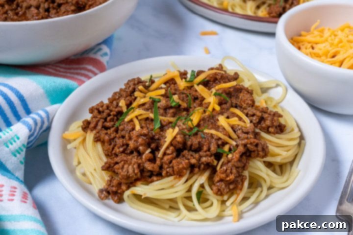 The Legend of Terlingua Chili 9 A delicious bowl of Terlingua chili served over spaghetti and garnished with shredded cheese, illustrating the 'Three-Way' style.