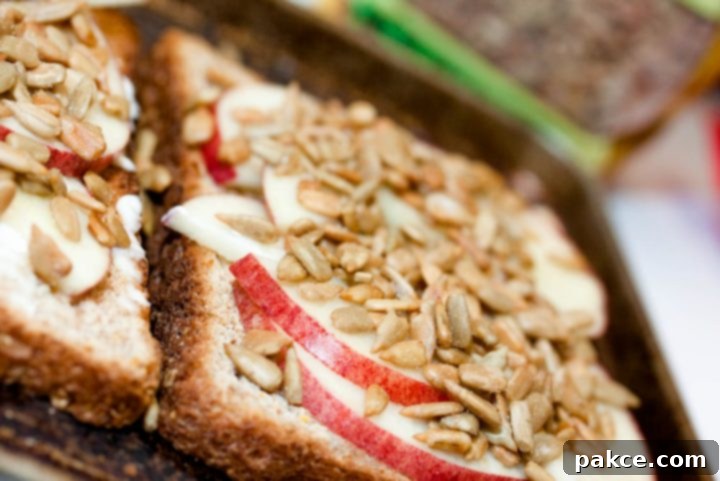 toast spread with mayo, apple slices, and sunflower seeds and text Add Salt & Serve