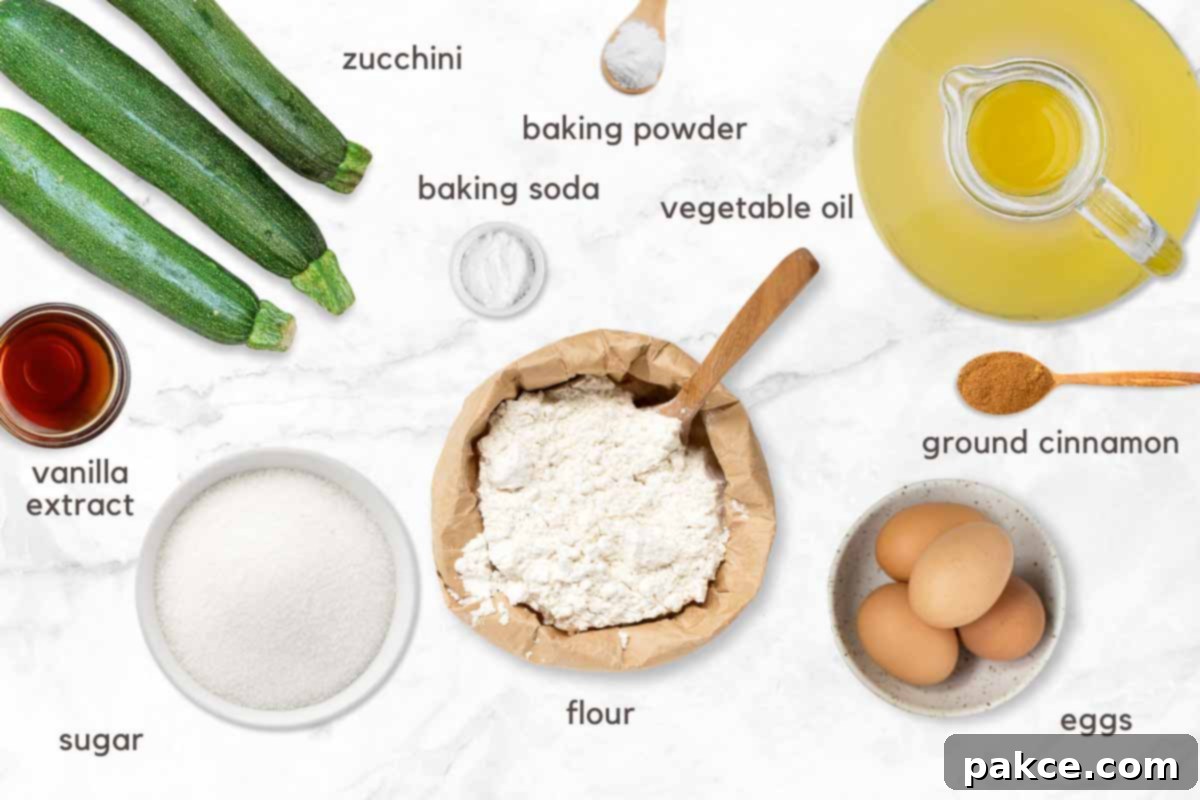 Effortless Zucchini Loaf 3 A flat lay photograph showcasing all the fresh ingredients for homemade zucchini bread, including shredded zucchini, flour, sugar, eggs, oil, vanilla, and spices, neatly arranged on a kitchen counter.
