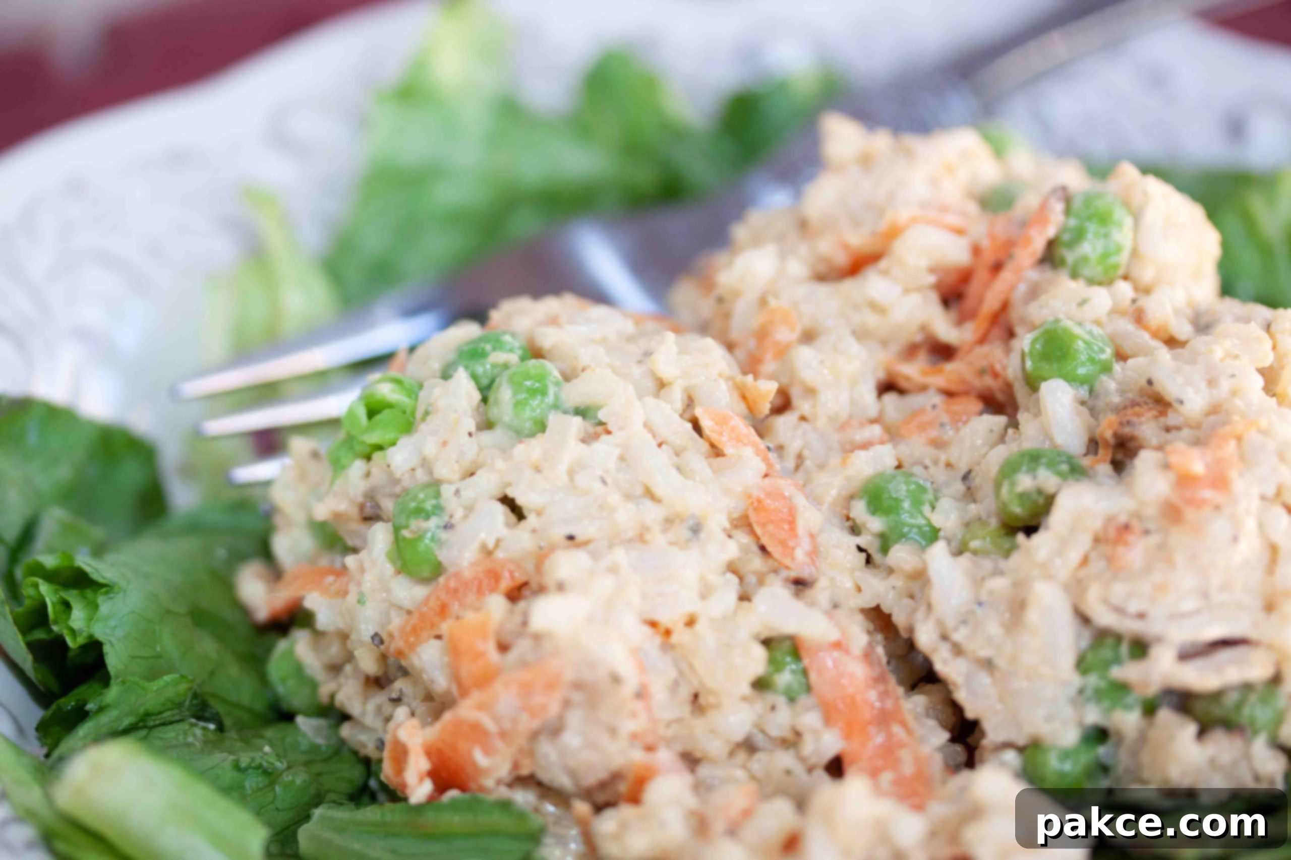 Cold rice salad with chicken and peas on a bed of lettuce. A healthy, versatile meal option.