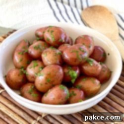 Simple Buttered Red Potatoes 3 A bowl of perfectly boiled baby red potatoes, generously coated in melted butter and garnished with fresh chopped parsley.
