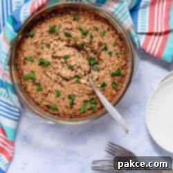 Golden French Onion Rice 3 French Onion Rice garnished with parsley in a casserole dish with a serving spoon.