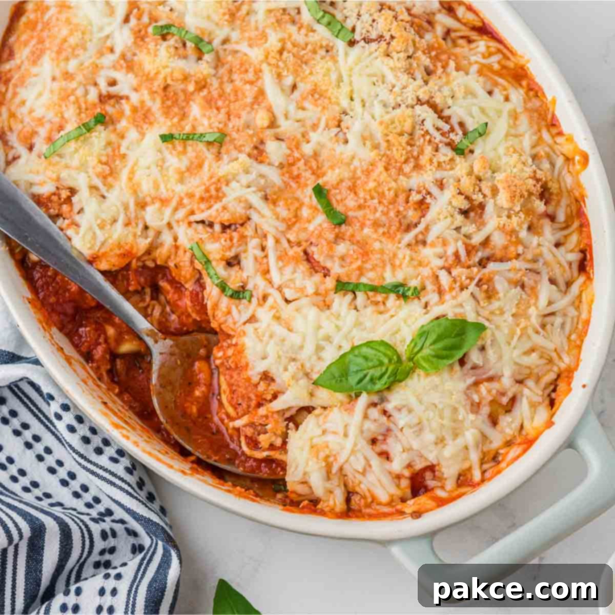 Casserole dish of baked frozen ravioli with a serving removed.