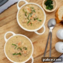 Slow Cooker Cheeseburger Comfort 9 Two bowls of hash brown soup in white crocks beside fresh basil strips in a small bowl and two spoons.