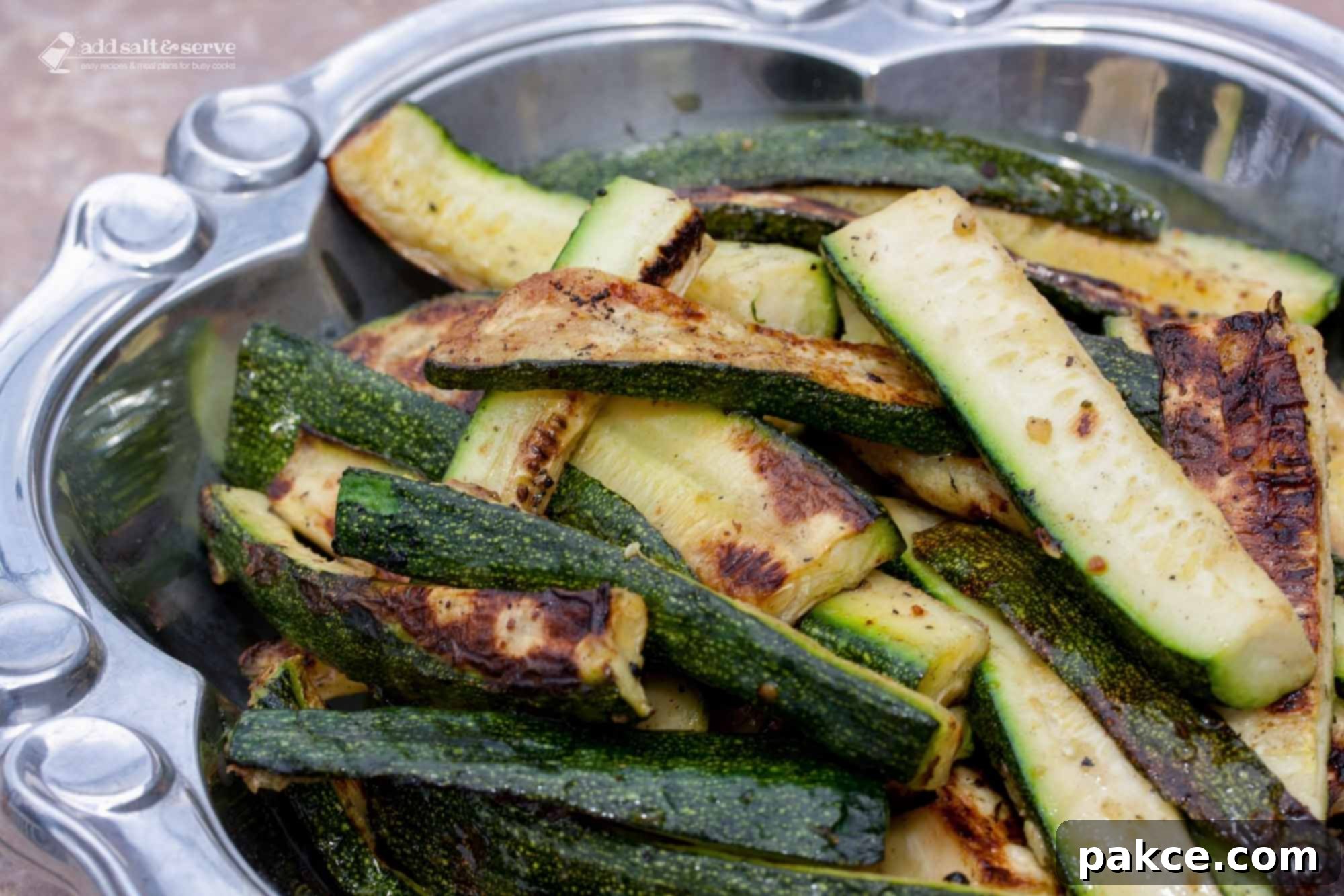 Perfectly grilled zucchini slices in a serving bowl, ready for a summer meal.