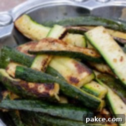 Grilled Zucchini Perfection 4 Grilled, sliced zucchini in a pewter serving bowl.