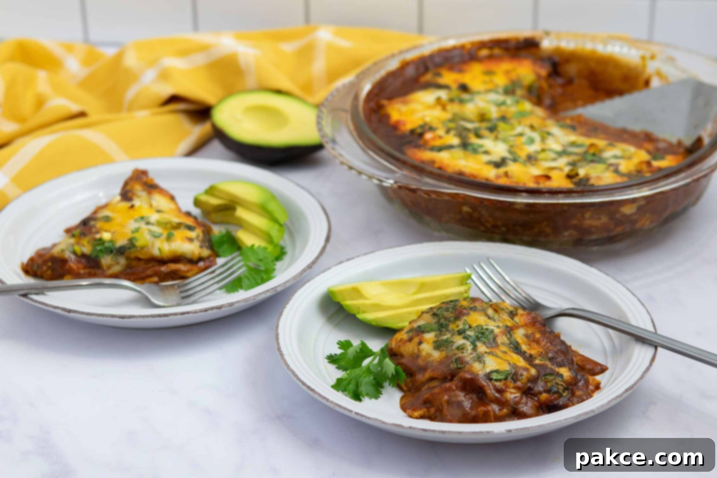 Two plates of a delicious, layered chicken enchilada bake, garnished with fresh sliced avocado, ready to be served for a family dinner.