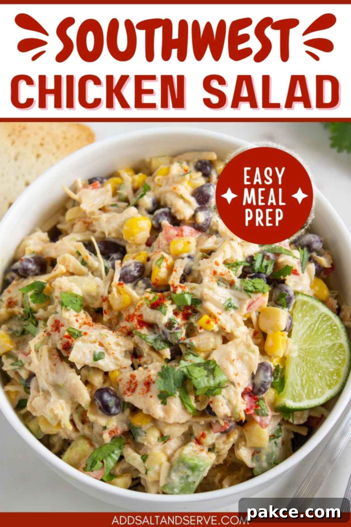 Fiesta Lime Chicken Salad 6 Bowl of chicken salad with corn, black beans, avocado, and red bell pepper in a creamy dressing garnished with a lime wedge and sprinkled with paprika with text Southwest Chicken Salad - easy meal prep.