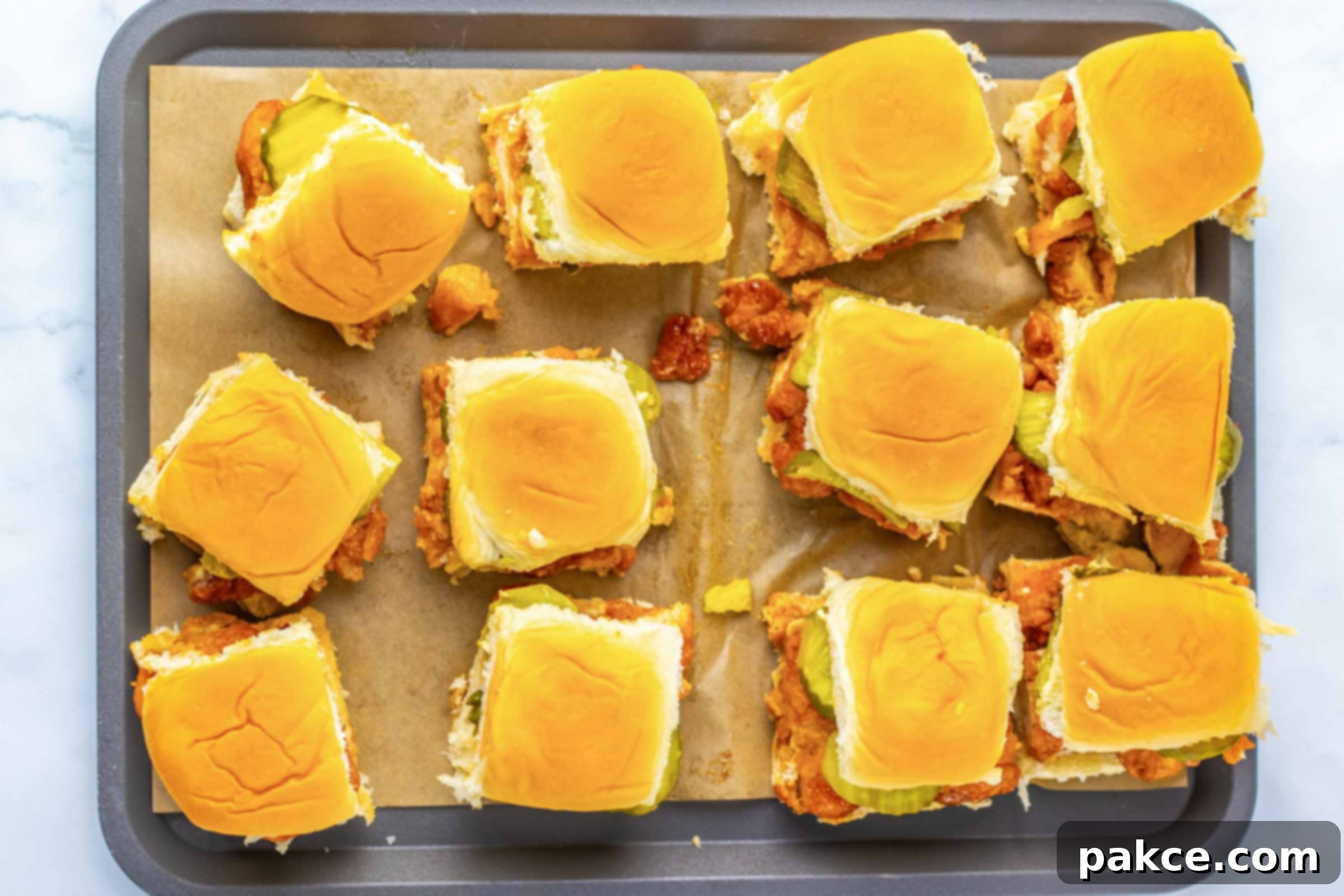 Sweet Heat Chicken Sliders in a Snap 8 Overhead view of a dozen hot honey chicken sliders on a baking sheet.