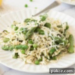 Zesty Orzo Pasta with Spring Greens and Parmesan 6 Plate of orzo with peas and asparagus garnished with grated Parmesan cheese.