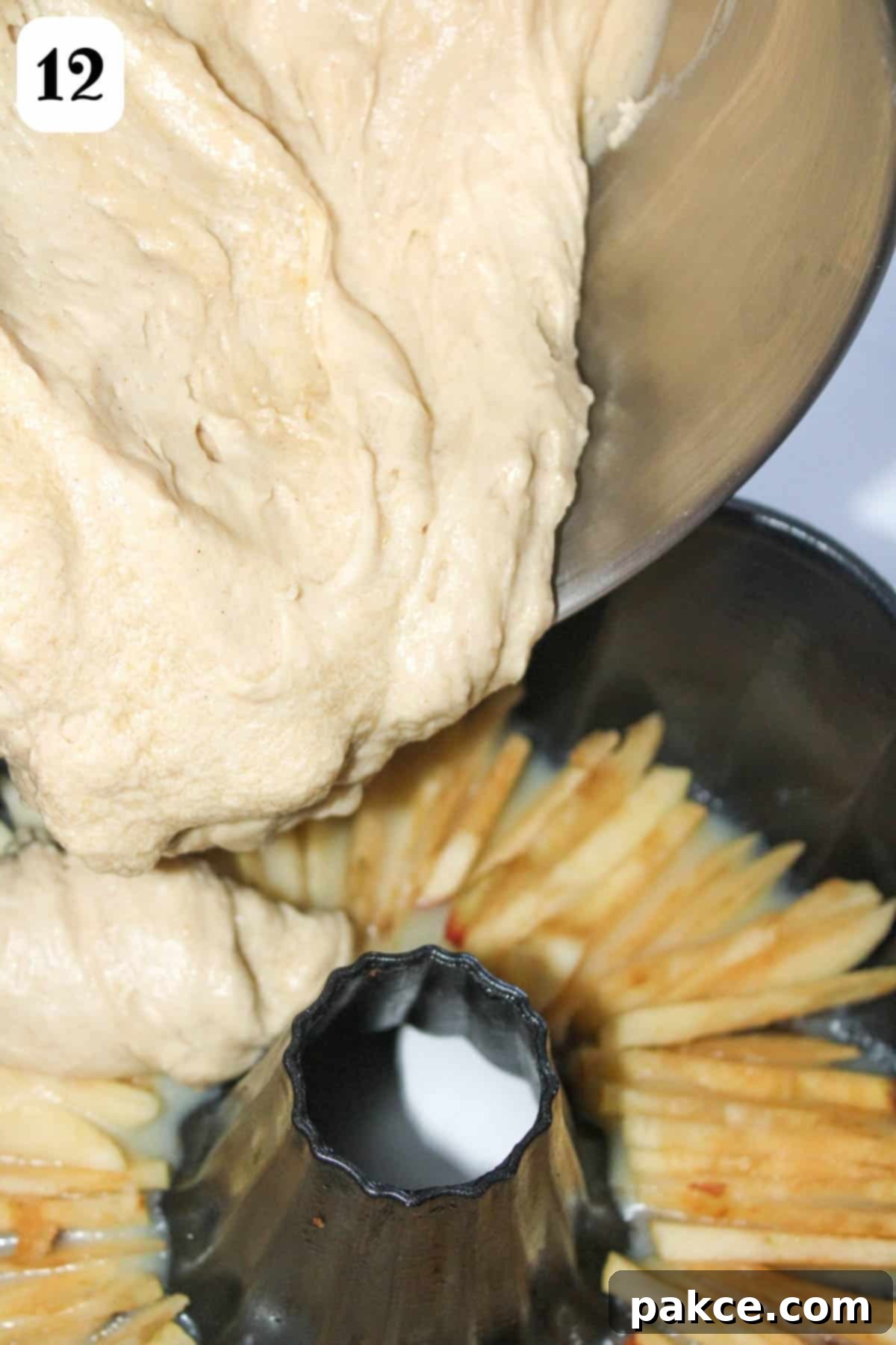 Caramelized Apple Bundt Inversion 8 Carefully adding the rich cake batter directly over the beautifully arranged sliced apples in a bundt pan, ensuring full coverage.