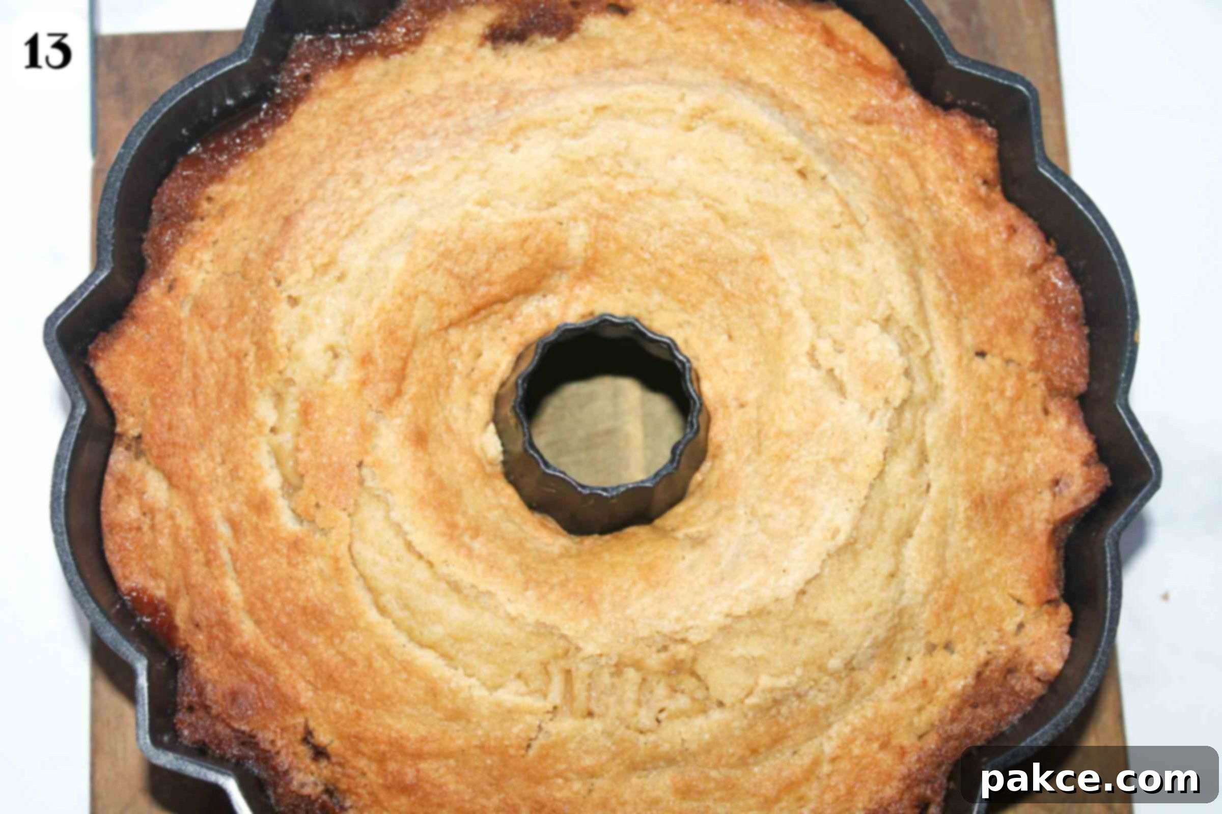 Caramelized Apple Bundt Inversion 9 The freshly baked Caramel Apple Upside Down Bundt Cake still in its bundt pan, showing a golden-brown top and ready for cooling and inversion.