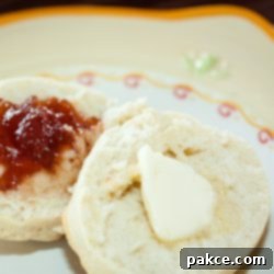 Effortless 3-Ingredient Buttermilk Biscuits 2 Biscuit cut in half with butter on one half and fruit preserves on the other half on a yellow and white plate
