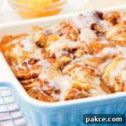 Apple cinnamon roll bake in pan with glaze on top.