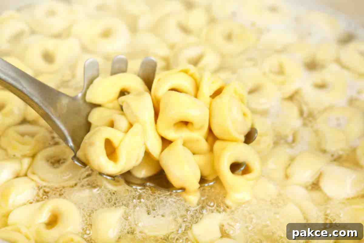Creamy Turkey Tortellini Bake 4 Cheese tortellini boiling in a large pot of salted water on the stovetop, releasing steam.