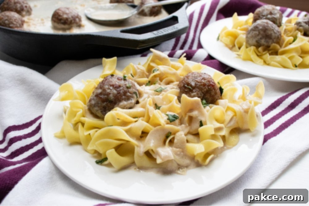 Creamy balsamic sauce with meatballs Cast iron skillet with chopped onion sautéing and meatballs in a round baking pan to the side