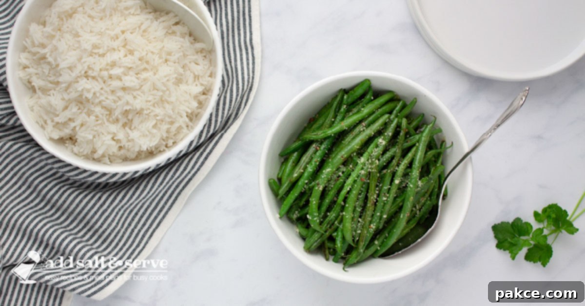 A serving bowl of cooked Seasoned Green Beans beside a serving bowl of white rice.