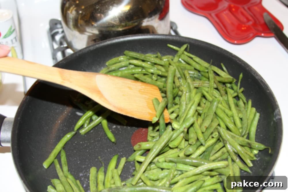 Green Beans Seasoned with Italian Dressing green beans being sautéed in a black frypan