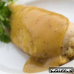 Sweet and Tangy Maple Dijon Chicken 2 White plate with chicken breast topped with a Dijon sauce.