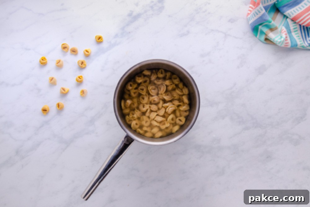 Tortellini cooking in boiling water, preparing for the soup