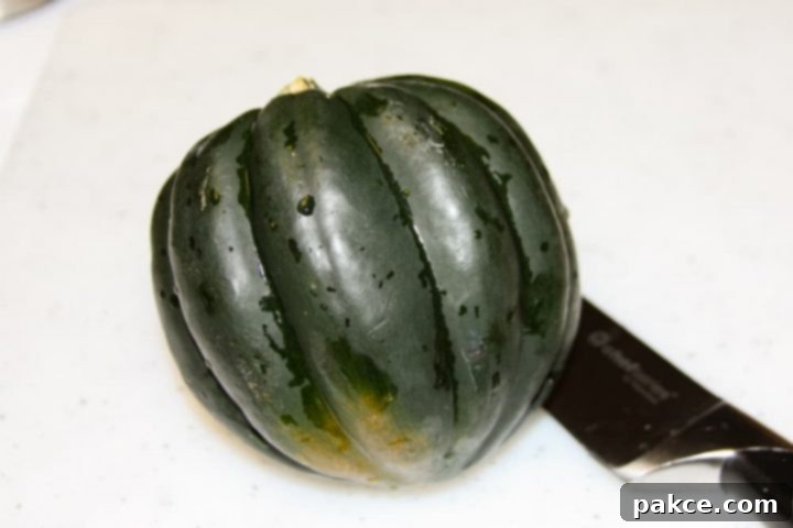 easy-microwave-acorn-squash-ip-6 copy-min Whole acorn squash on a cutting board with a knife