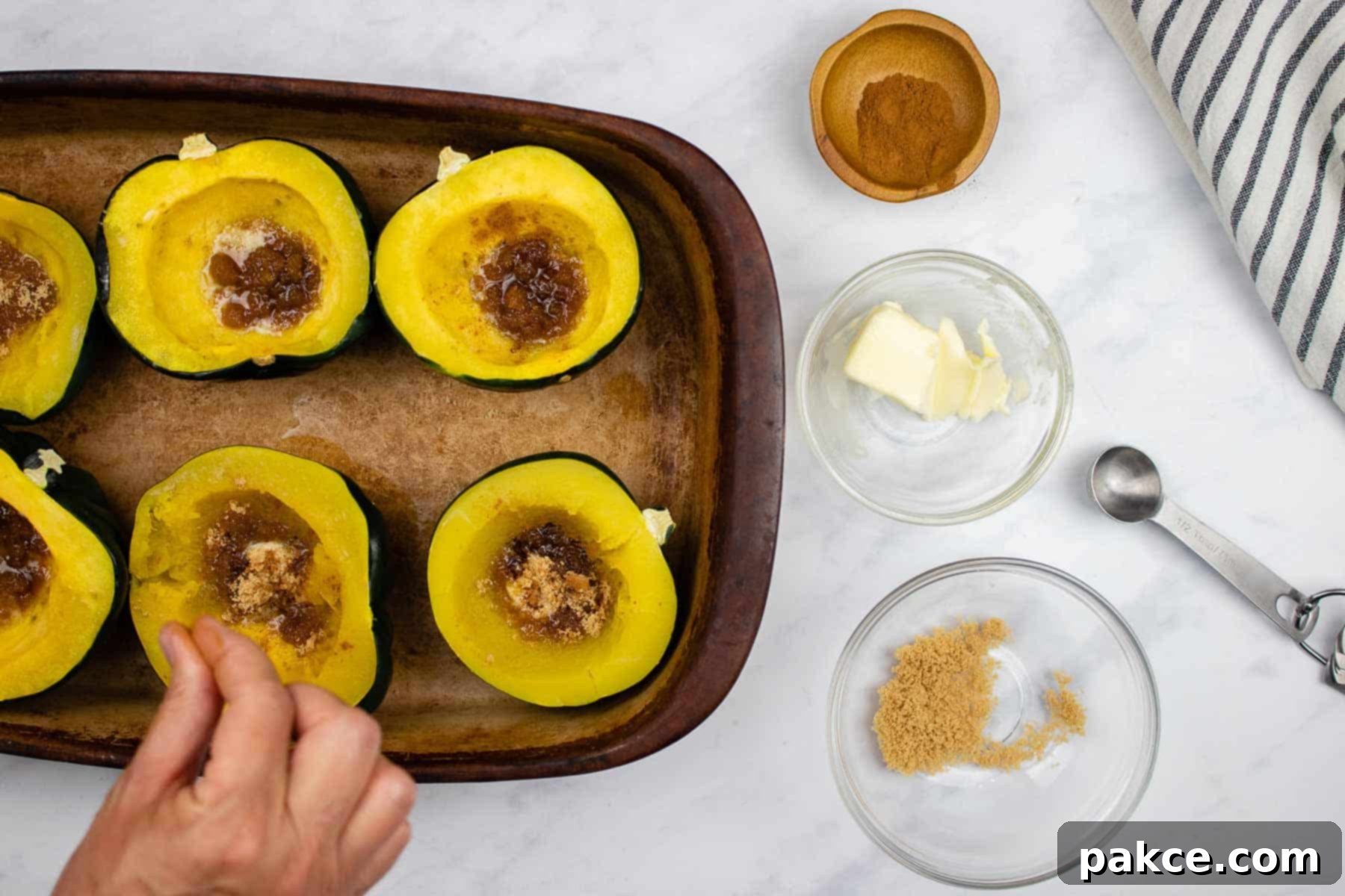 Easy Microwave Acorn Squash 6 Adding cinnamon to cooked acorn squash halves with butter and brown sugar.