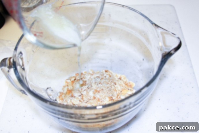 Mixing crushed crackers with melted butter