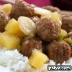 Sweet and Sour Meatballs with Fluffy Rice 2 Meatballs, water chestnuts, and pineapple chunks in sauce over white rice, text Sweet and Sour Meatballs #quickandeasy
