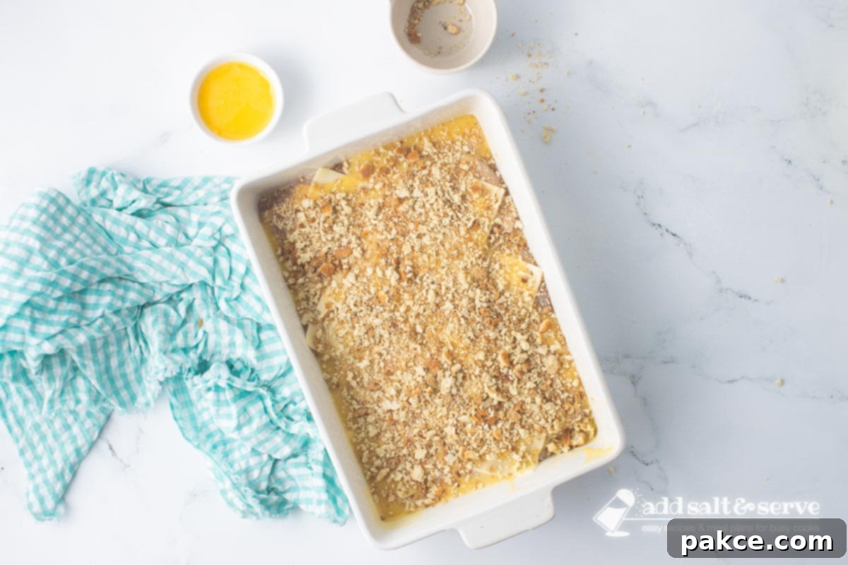 Baked Swiss Chicken with White Wine 8 Casserole dish of Swiss chicken with white wine and stuffing before adding melted butter to the top of the stuffing.