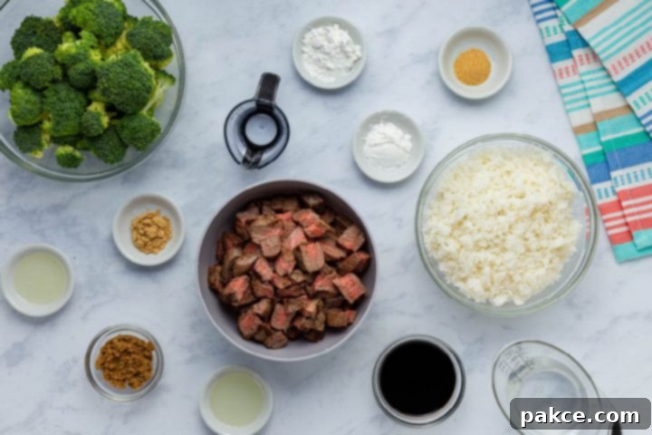 Leftover Steak Beef and Broccoli Makeover 2 Ingredients laid out for Beef and Broccoli Stir Fry: leftover steak, soy sauce, fresh broccoli, cooked rice, garlic powder, oil, salt, pepper, brown sugar, ground ginger, and optional sesame oil.