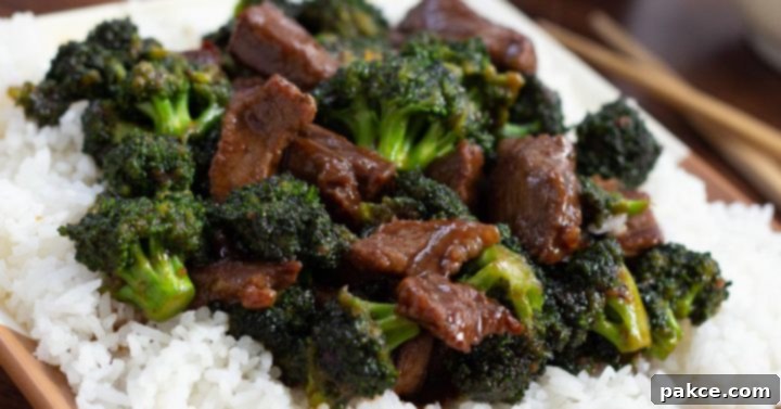 Leftover Steak Beef and Broccoli Makeover 6 A serving of Easy Beef and Broccoli Stir Fry with slices of beef and bright green broccoli florets in a rich soy-based sauce, served over fluffy white rice on a white plate with chopsticks on the side.